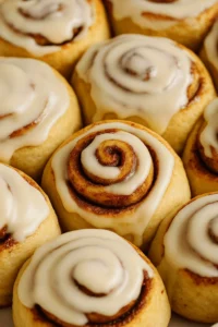 Close-up of cinnamon rolls topped with glaze made from a cinnamon roll icing recipe